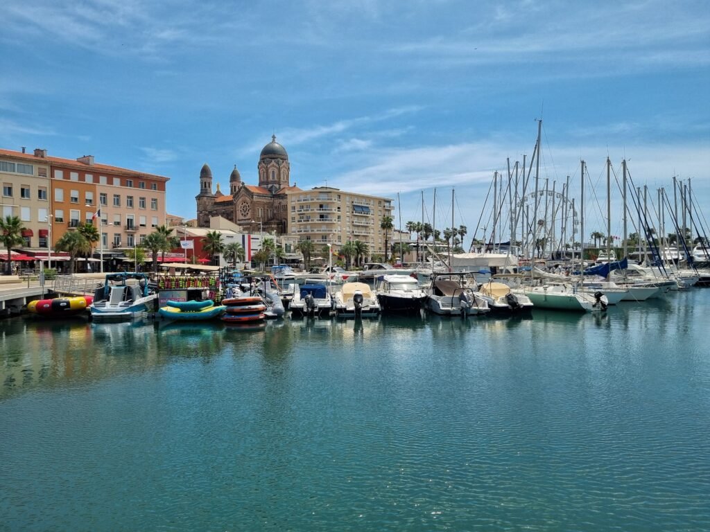 Scenic view of Saint-Tropez marina with boats and the iconic cathedral on a sunny day.