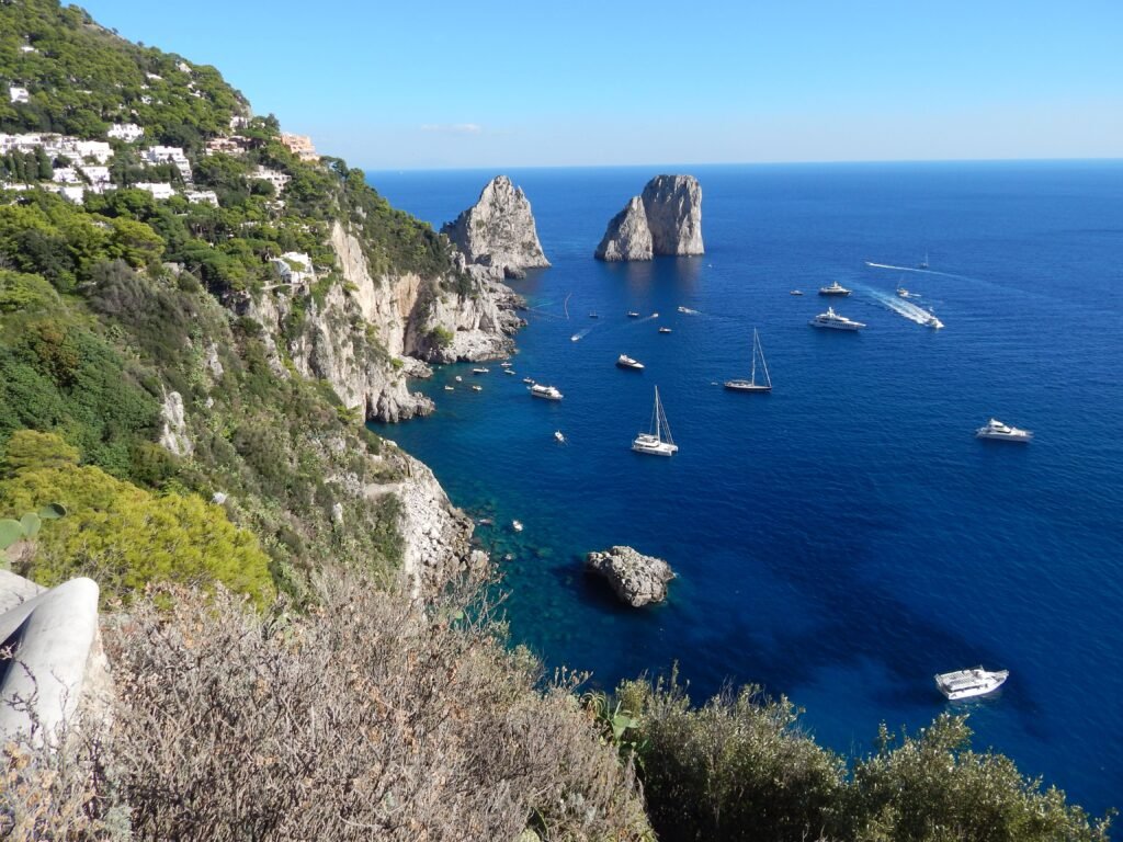 Breathtaking view of Capri's coastline with boats and blue waters, perfect for travel enthusiasts.