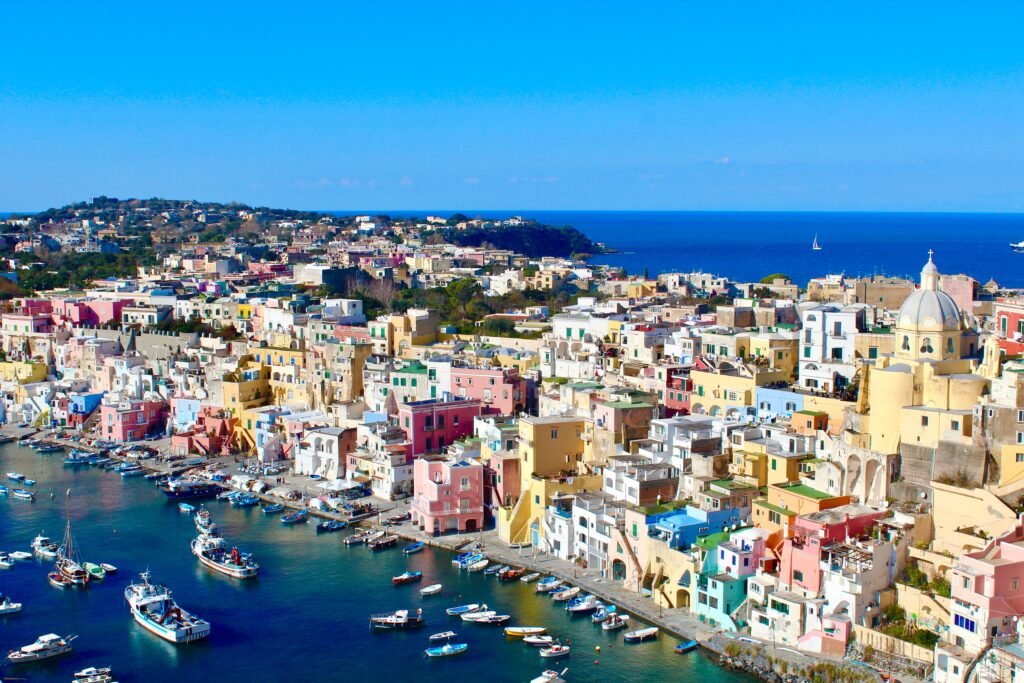 Explore the vibrant and picturesque waterfront of Procida Island, Italy with its colorful buildings and marina.